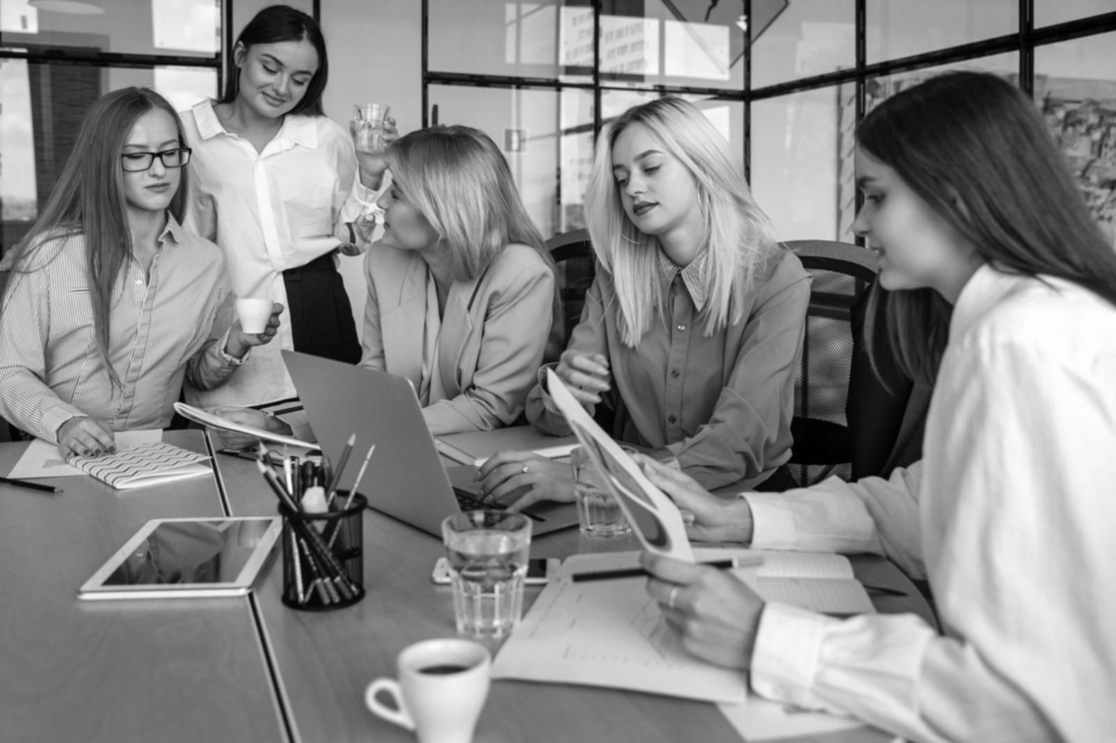 Professional reviewing financial documents and market data on digital screens